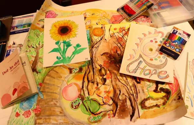 Artworks from a session: a sunflower, a tree and the word Hope, with coloured pencils